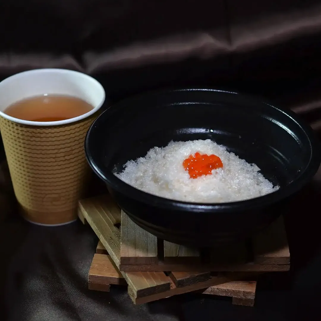 【土日祝限定販売】雪解け茶漬<br>降り積もった雪に、自慢の出汁をそそぐと、あおさがふわりと広がり、まるで春の雪解けを思わせる風景に。白い“粉雪”の正体は、人気商品「竈出汁」と相性抜群の「たま麩」。とろける食感のお麩と、自慢のご飯のお供をぜひご一緒に。<br>1月26日までの期間限定販売です。  900円（税込）